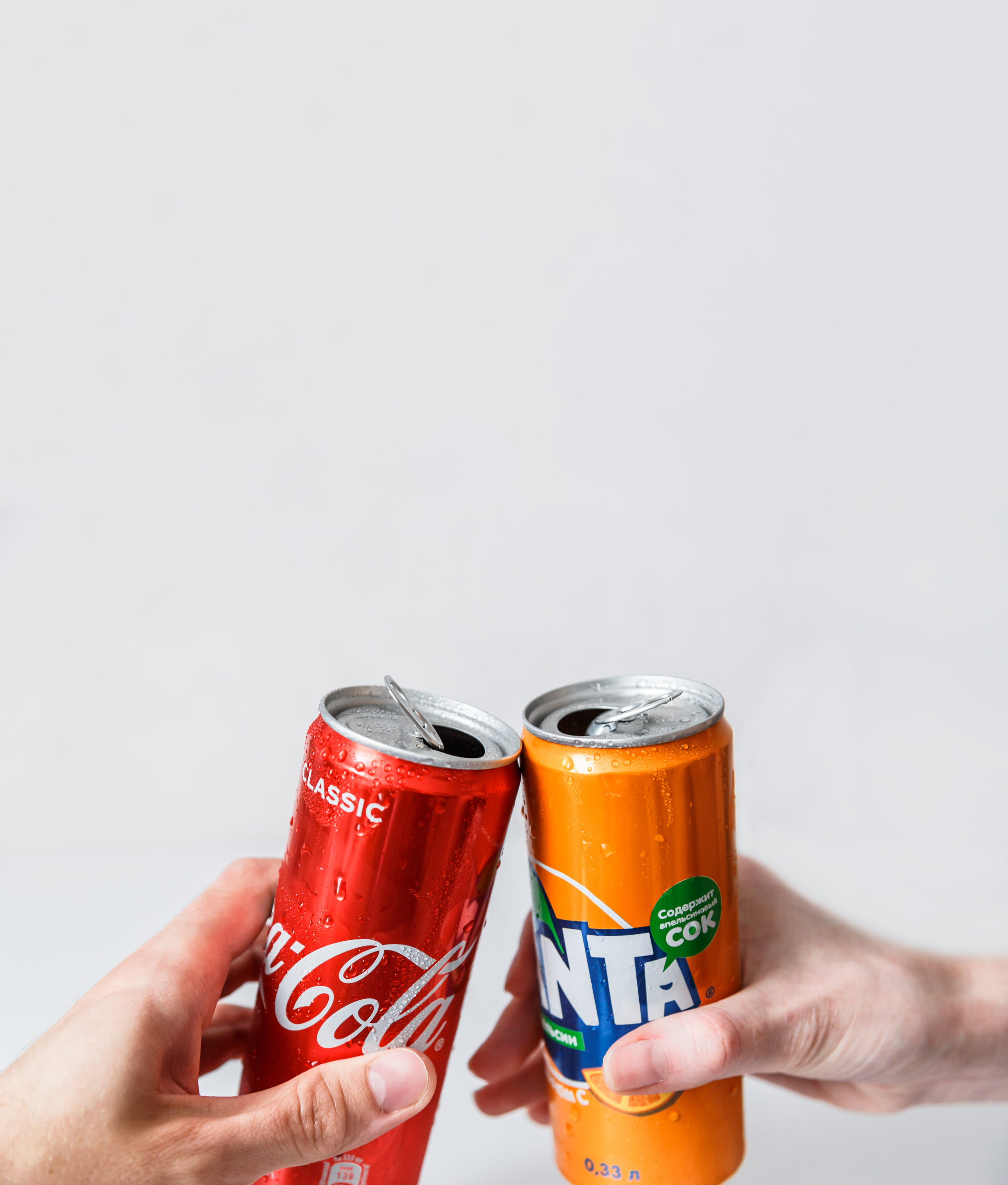 People Holding Canned Softdrinks